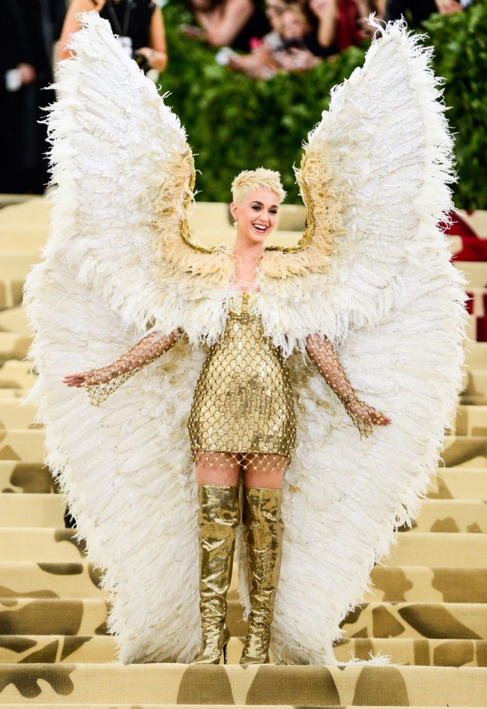 Katy Perry 也以 Atelier Versace 高級訂製服出場。她以搶眼的金屬網布短洋裝搭配長靴，一雙誇張的巨型羽毛翅膀成為眾人焦點，好似落入凡間的天使！
